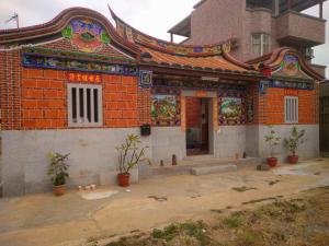 ein Gebäude mit orangefarbenem Backstein und einem Gebäude mit Ahtar in der Unterkunft Lanhu Song B&B in Jinhu
