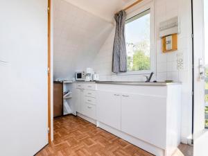 a kitchen with white cabinets and a window at Magnificent flat with garden in Saint R my in Clécy