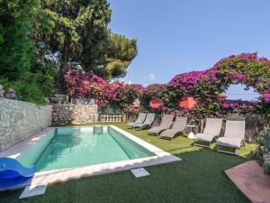 - une piscine entourée de chaises et de fleurs dans la cour dans l'établissement Villa with private pool and sublime views, à Èze