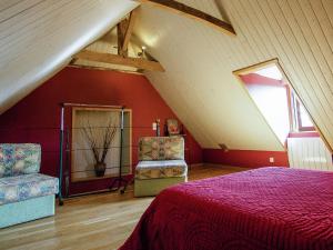 a attic room with a bed and two chairs at Comfortable g te with swimming pool in Laval