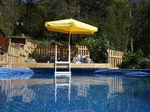 um guarda-chuva amarelo sentado no meio de uma piscina em Pretty chalet in Beaulieu with private pool em Beaulieu