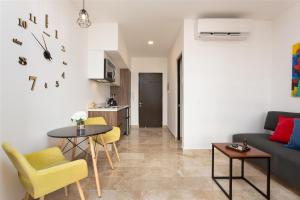 un salon avec un canapé, une table et des chaises dans l'établissement Studio Vanessa beach 42 a 1 min de la playa y 5ta av, à Playa del Carmen