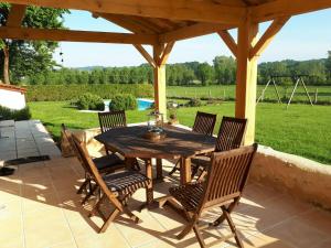 a wooden table and chairs on a patio at Holiday home with pool in Verteillac in Verteillac