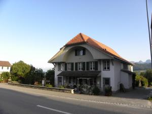 ein großes weißes Gebäude an der Seite einer Straße in der Unterkunft Bed and Breakfast Gantrisch Cottage Ferienzimmer in Rüeggisberg