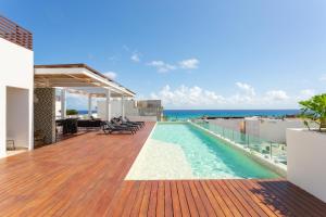une piscine sur le toit d'un immeuble avec l'océan dans l'établissement Studio Vanessa beach 42 a 1 min de la playa y 5ta av, à Playa del Carmen