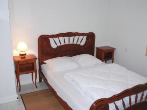 un lit avec une tête de lit en bois et 2 tables de chevet dans l'établissement Cosy holiday home 700m from the beach, à Erquy