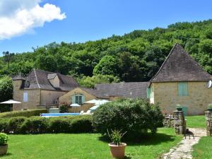 a house with a swimming pool in a yard at Stone house with shared pool near Sarlat in Prats-de-Carlux