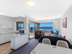 cocina y sala de estar con vistas al océano en Dolphin Court 6, en The Entrance