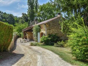 a stone cottage on a dirt road at Traditional holiday home with pool in Saint-Cernin-de-lʼHerm