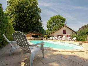 a swimming pool with lounge chairs and a house at Charming Cottage with Pool in V zac South of France in Beynac-et-Cazenac