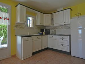 una cucina con armadietti bianchi e frigorifero bianco di Spacious holiday home with private pool a Saint-Maximin