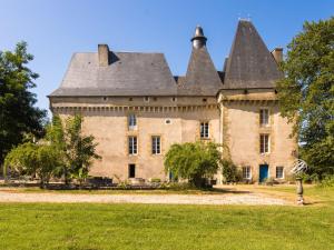 an old castle with a roof on a grass field at Very spacious cottage with a separate guest house on a medieval domain in Chaleix