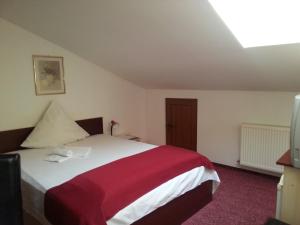 1 dormitorio con 1 cama con manta roja y blanca en Pensiunea Pura Vida, en Timisoara