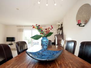 a blue vase with flowers on a wooden table at Modern villa near the sea with balcony in Aigues-Mortes