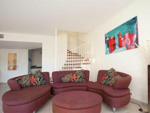 een woonkamer met een bank en 2 stoelen bij Modern villa near the sea with balcony in Aigues-Mortes