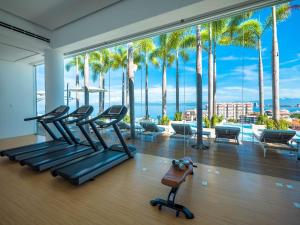 a gym with a view of the ocean and palm trees at PIER 57 - 709 Stunning View 2 BR Romantic Zone in Puerto Vallarta +74 photos