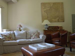 a living room with a couch and a table at Luxury country house with heated private pool in Courniou