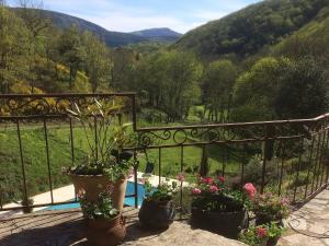 a balcony with potted plants and a view of a mountain at Luxury country house with heated private pool in Courniou