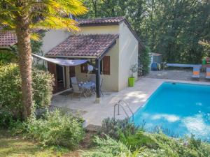 uma pequena casa com piscina num quintal em Quiet holiday home with large pool em Saint-Martin-le-Redon