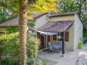 uma casa com uma palmeira em frente em Quiet holiday home with large pool em Saint-Martin-le-Redon