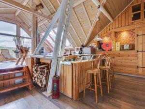 a kitchen with a bar and stools in a cabin at Loft with jacuzzi and sauna in Niderviller