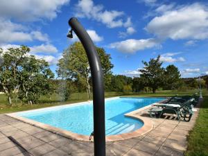 a swimming pool with a light pole next to it at Vintage Holiday Home in Besse with Swimming Pool in Saint-Pompont