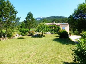 a large yard with a house in the background at Quiet holiday home with garden in Ponet-et-Saint-Auban