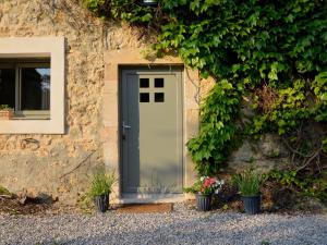 uma porta de um edifício de pedra com plantas na frente em Holiday home with private garden in Wierre Effroy em Rinxent