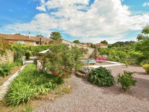 Félines-MinervoisにあるHoliday home with swimming poolの植物と家の庭のある裏庭
