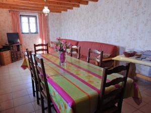 a dining room table with a vase of flowers on it at Spacious holiday home near the forest in Esmoulières