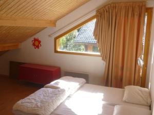 - une chambre avec un lit blanc et une fenêtre dans l'établissement Spacious chalet near the ski area, à Saint-Jean-dʼAulps