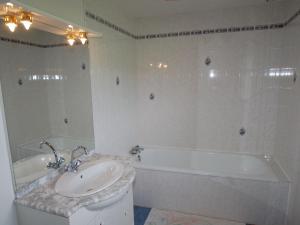 a bathroom with a tub and a sink and a bath tub at Superb villa by the sea in Poggio Mezzana in Saint-Floxel