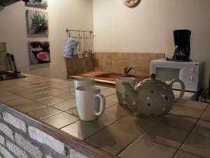 a kitchen counter with two mugs and a tea kettle at Holiday home in Quend Plage les Pins with pool in Quend