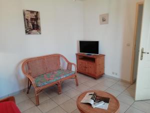 salon z krzesłem, stołem i telewizorem w obiekcie Holiday home with swimming pool w mieście Quend