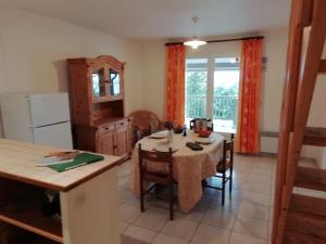 kuchnia ze stołem i krzesłami oraz kuchnia z oknem w obiekcie Holiday home with swimming pool w mieście Quend