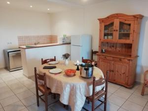 y cocina con mesa, sillas y nevera. en Holiday home with swimming pool, en Quend