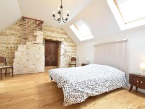 a bedroom with a bed and a brick wall at Spacious holiday home in Sormery with pool in Sormery