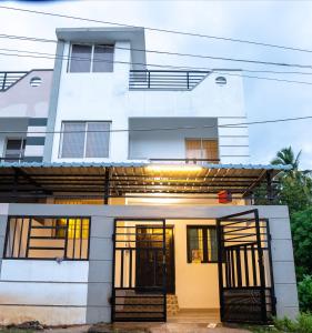 una casa blanca con las puertas delanteras abiertas en Fiji Villa, en Pondicherry