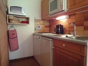 a small kitchen with a sink and a microwave at South facing flat with balcony in Méribel