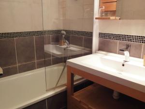 a bathroom with a sink and a shower and a tub at South facing flat with balcony in Méribel