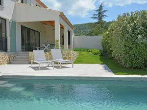 a house with two chairs and a swimming pool at Superb villa with heated pool in Malauc ne in Malaucène