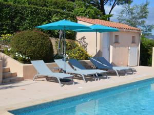 - un groupe de chaises longues et de parasols à côté de la piscine dans l'établissement Bright villa in Sainte Maxime with private pool, à Sainte-Maxime