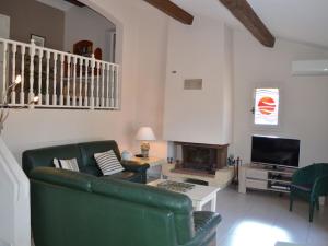 - un salon avec un canapé vert et une cheminée dans l'établissement Bright villa in Sainte Maxime with private pool, à Sainte-Maxime