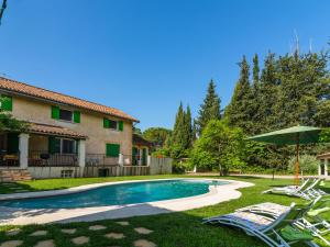 a swimming pool with lawn chairs and an umbrella at Inviting villa in Lorgues with enclosed garden in Lorgues