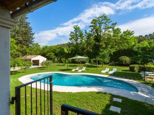 a swimming pool in a yard with chairs and trees at Inviting villa in Lorgues with enclosed garden in Lorgues