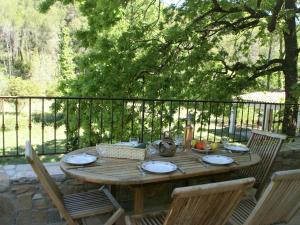 ドラギニャンにあるCharming house in the forest with private poolの木製テーブルと椅子付きのパティオ