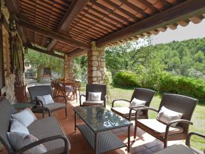 eine Außenterrasse mit Stühlen, Tischen und einer hölzernen Pergola in der Unterkunft Charming Villa in Callas with Private Swimming Pool in Callas