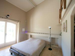 een slaapkamer met een bed en een groot raam bij Luxury villa in Provence with a private pool in Martres-Tolosane