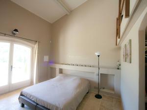 a bedroom with a bed and a large window at Luxury villa in Provence with a private pool in Martres-Tolosane