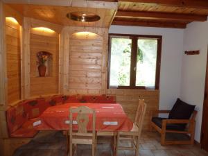 een eetkamer met een rode tafel en stoelen bij Quaint Chalet in Ventron with Roofed Terrace in Ventron